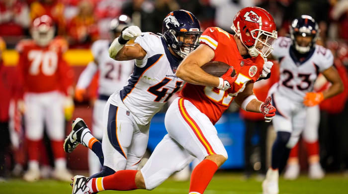 Dec 5, 2021; Kansas City, Missouri, USA; Kansas City Chiefs tight end Travis Kelce (87) runs the ball against Denver Broncos linebacker Kenny Young (41) during the second half at GEHA Field at Arrowhead Stadium.